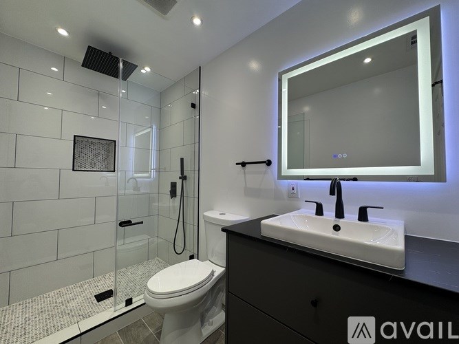 A bathroom with a white toilet, sink, and mirror.