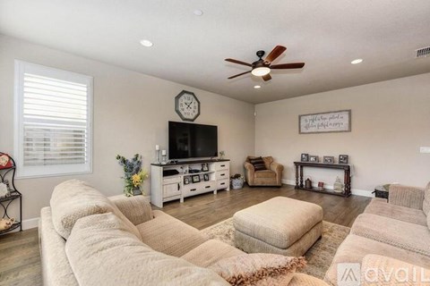 A living room with a beige sofa set and a television.