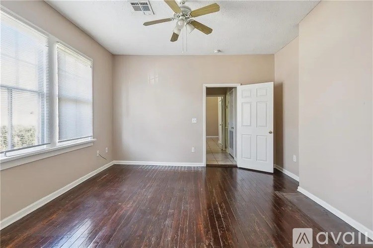A room with a wooden floor and a ceiling fan.