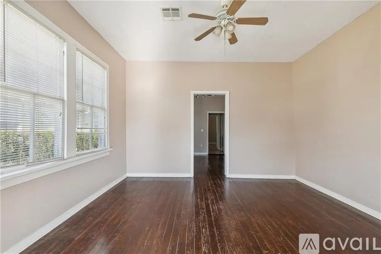 A room with a wooden floor and a ceiling fan.