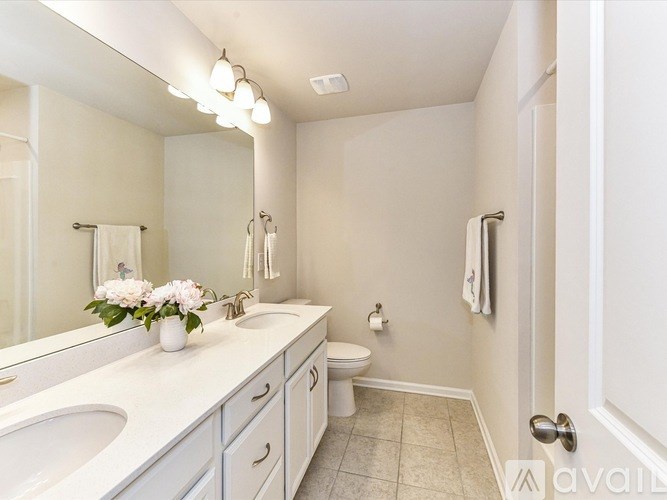 A bathroom with a white sink and a white toilet.