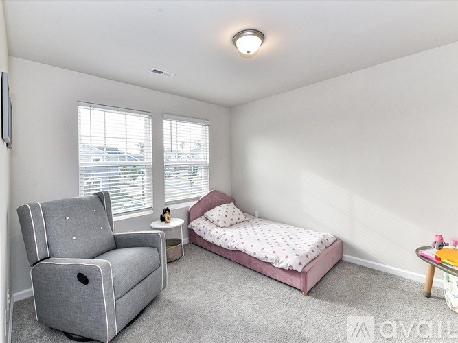 A bedroom with a bed, chair, and table.