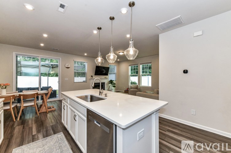 A kitchen with a white countertop and a dining table with chairs.