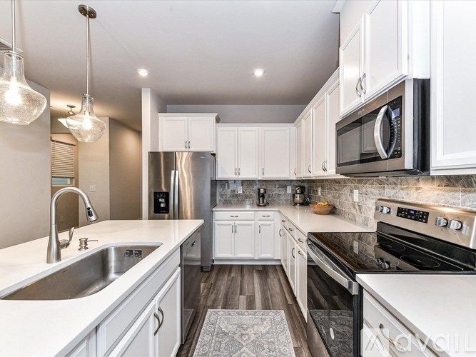 A modern kitchen with white cabinets and stainless steel appliances.