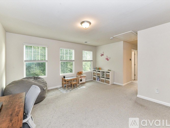 A living room with a grey bean bag chair and a wooden table.