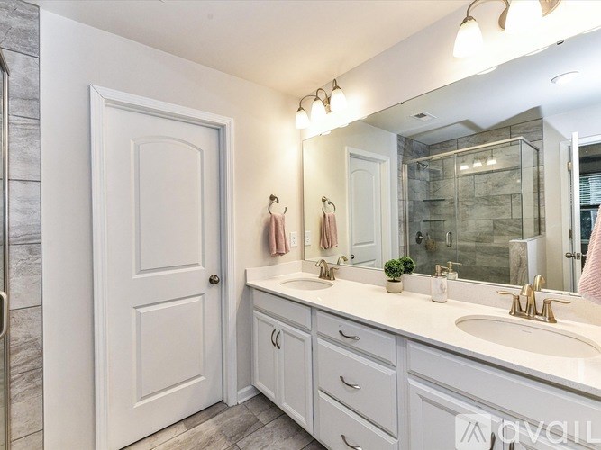 A white bathroom with a sink, mirror, and towel rack.
