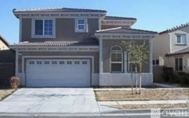 A house with a garage door and a tree in front.