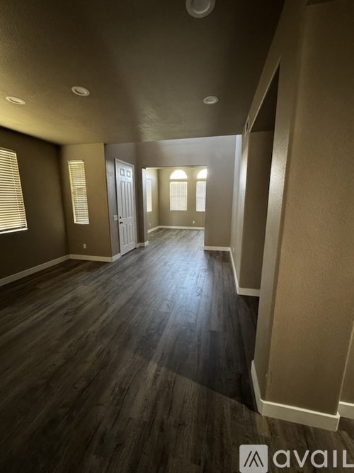 A hallway with wooden floors and a white door.