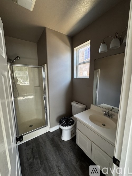 A bathroom with a toilet, sink, and shower.