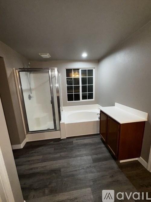 A bathroom with a tub, shower, and window.