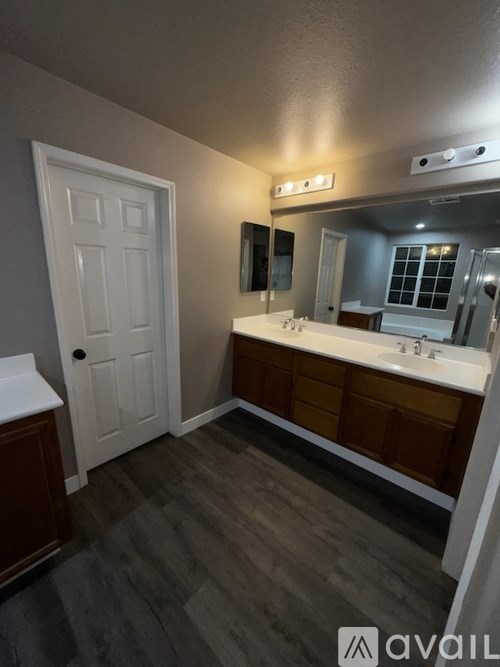 A bathroom with a white door and a brown cabinet.