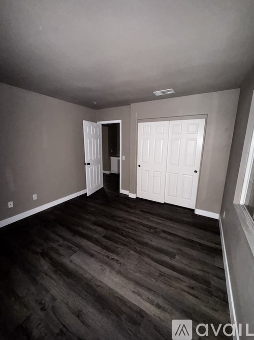 A room with wooden floors and two white doors.