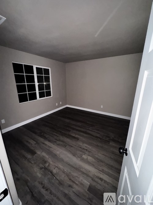 A room with wooden flooring and a window.