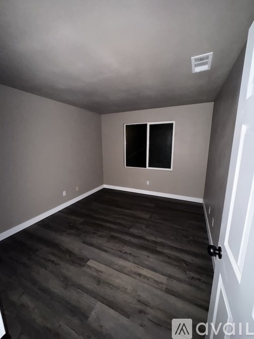 A room with a wooden floor and a window.