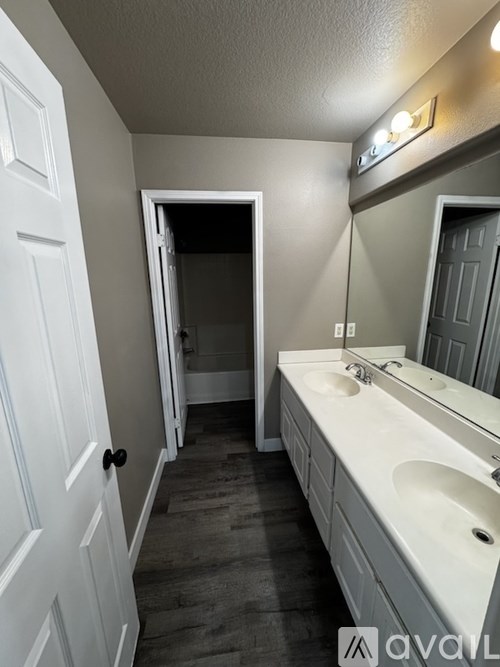 A bathroom with a white sink and a white door.
