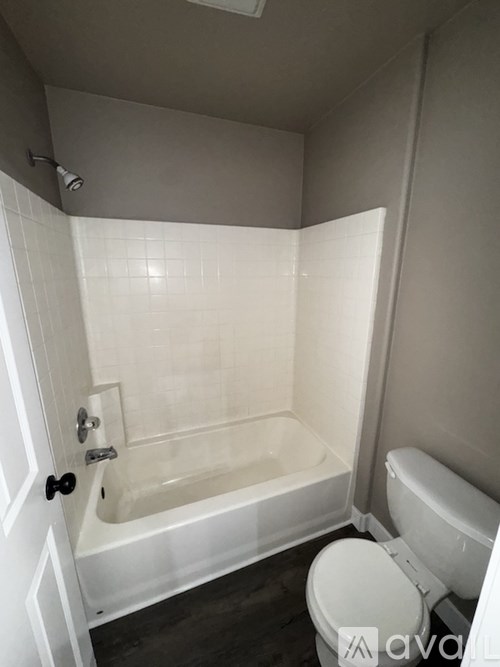 A white bathroom with a toilet, tub, and shower.