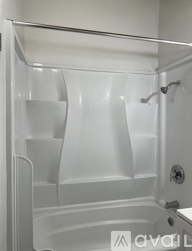 A white bathtub with a shower head and a faucet.