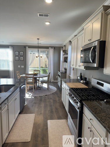 A kitchen with a table and chairs in the middle of the room.
