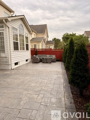 A patio with a table and chairs surrounded by a fence and trees.