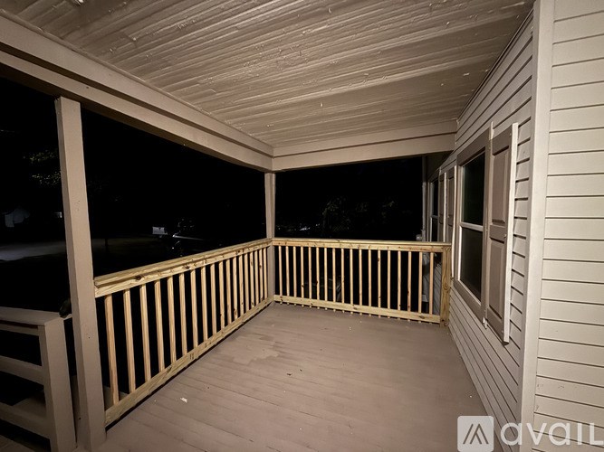 A room with a stone fireplace and wooden flooring.