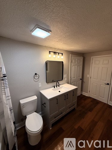A white bathroom with a toilet, sink, and shower.