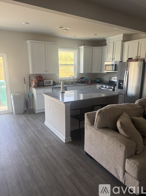 A kitchen with a refrigerator, sink, and cabinets.