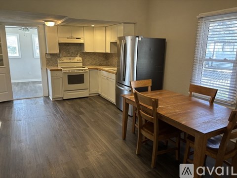 A kitchen with a table and chairs in front of it.