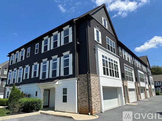 A large two-story building with a black and white exterior and multiple garage doors.