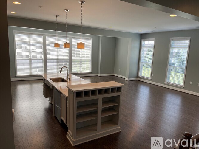 A kitchen with a wooden island and pendant lights.