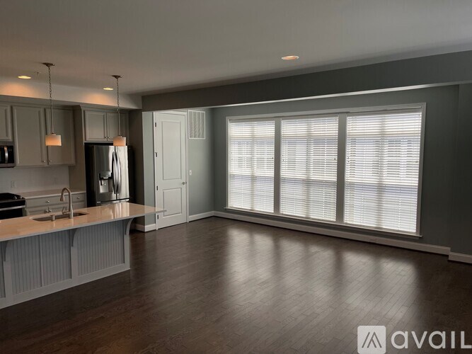 A modern kitchen with dark wood floors and white cabinetry.