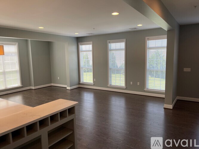 A spacious room with wooden flooring and a long table.