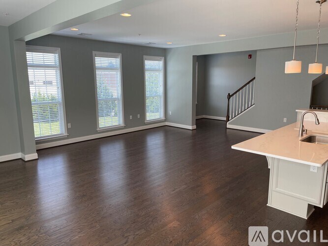A spacious room with wooden floors and a kitchen island.