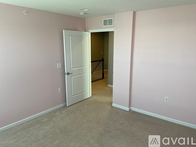 A room with a white door and carpeted floor.