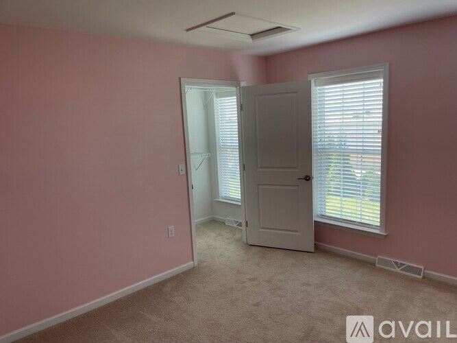 A room with pink walls and a white door.