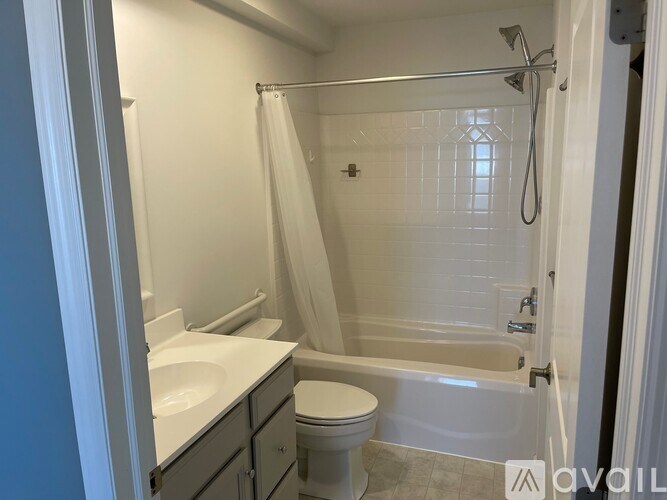 A white bathroom with a toilet, sink, and bathtub.