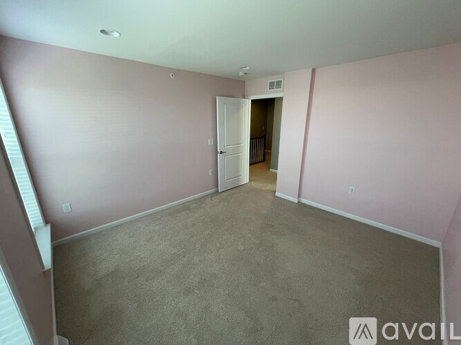A room with pink walls and a carpeted floor.
