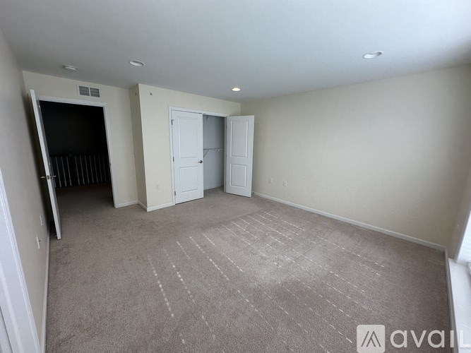 A room with pink walls and a white doorway leading to another room.