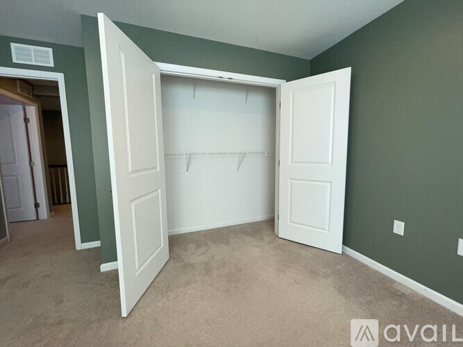 A room with a white door and a green wall.
