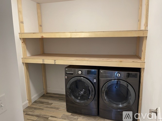 A bathroom with a marble shower wall and a glass door.