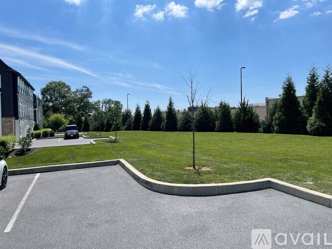 A parking lot with a car parked and a building in the background.