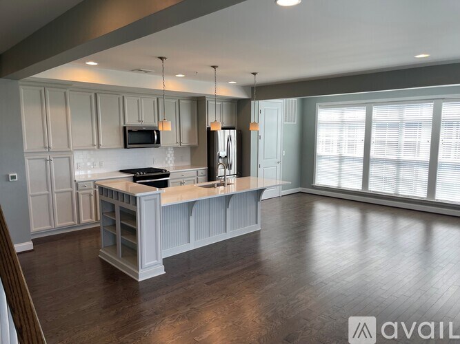 A kitchen with a wooden floor and a large island in the middle.