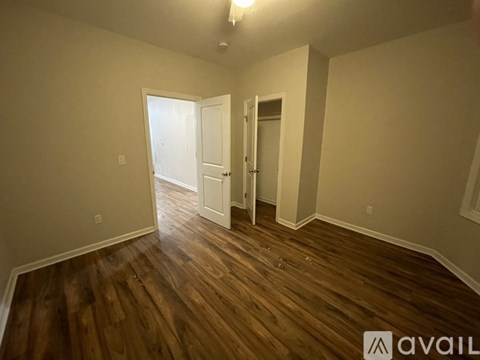 A room with wooden floors and two doors.