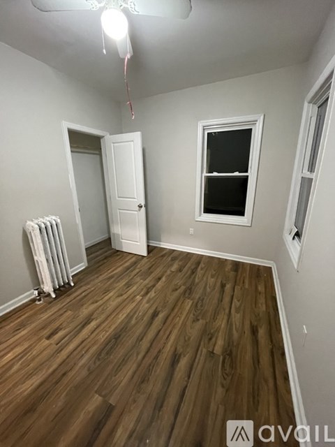 A room with wood flooring and a ceiling fan.
