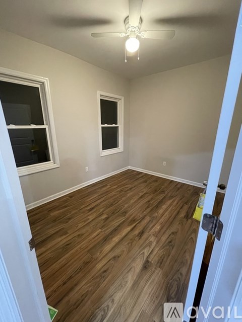 A room with wooden flooring and a ceiling fan.
