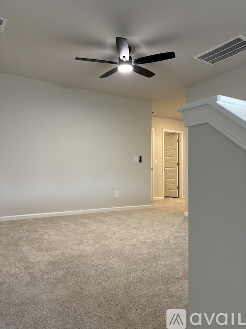 A room with a ceiling fan and a door.