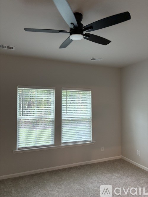 A white toilet in a small bathroom with a walk-in shower.