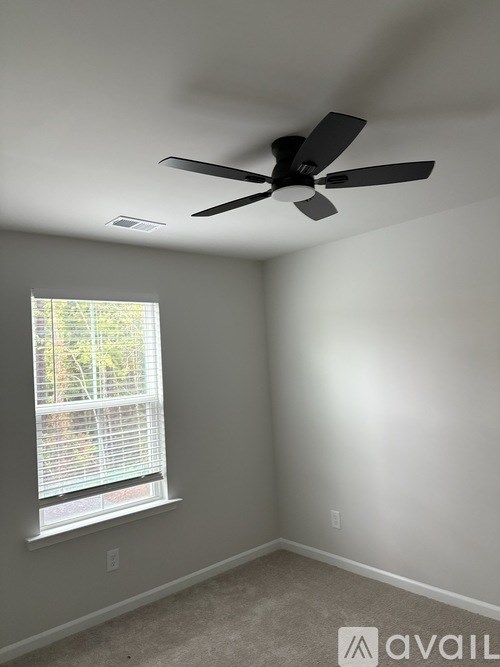 A room with a ceiling fan and a window.