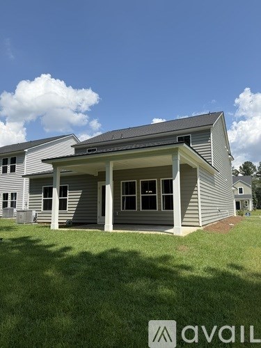 A house with a grey roof and a white wall with a window and a door.