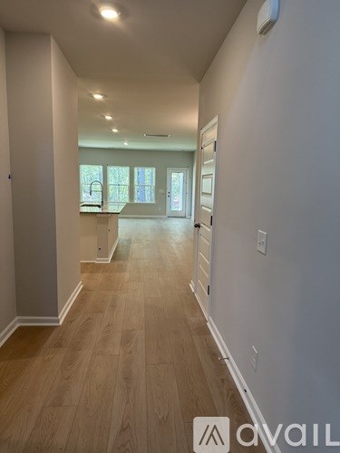 A long hallway with wood floors and white walls.