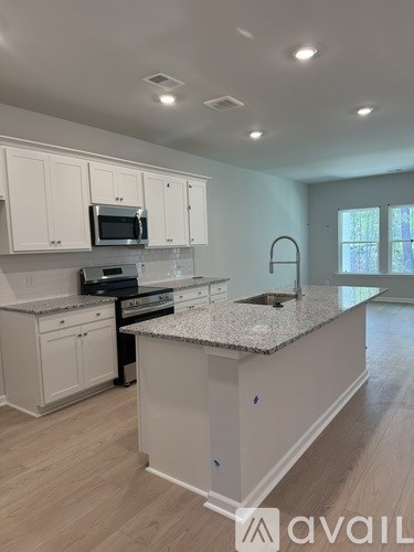A kitchen with white cabinets and a granite countertop.